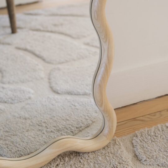détail grand miroir ondulé bois clair